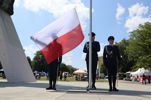 Na zdjęciu policjanci wciągający flagę Rzeczypospolitej Polskiej na maszt