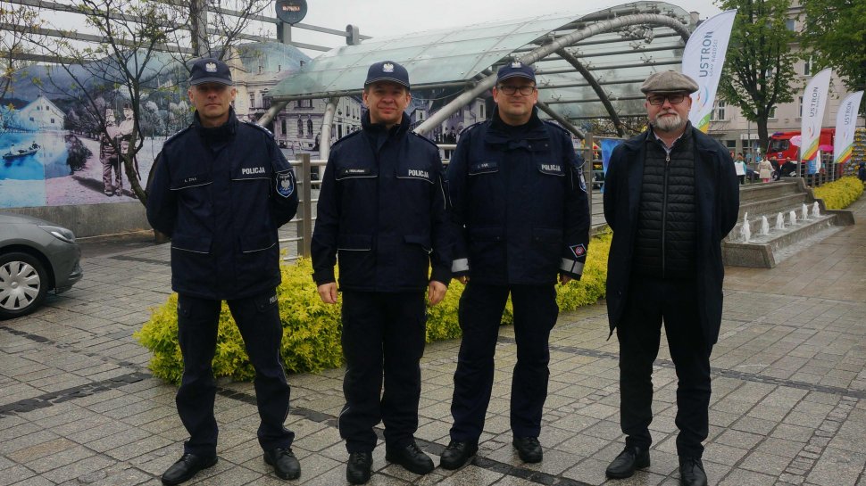 Zdjęcie przedstawia trzech umundurowanych policjantów, a po ich prawej stronie mężczyznę po cywilnemu