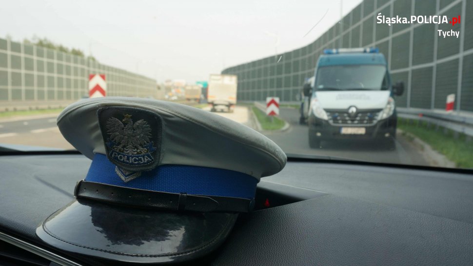 Na pierwszym planie widoczna z wewnątrz pojazdu czapka policjanta wydziału ruchu drogowego, dalej widoczny pojazd Inspekcji Transportu Drogowego.