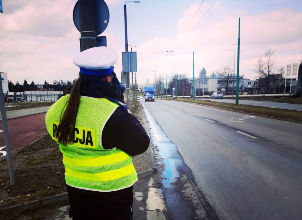 Policjantka ruchu drogowego mierzy prędkość ręcznym miernikiem prędkości. 