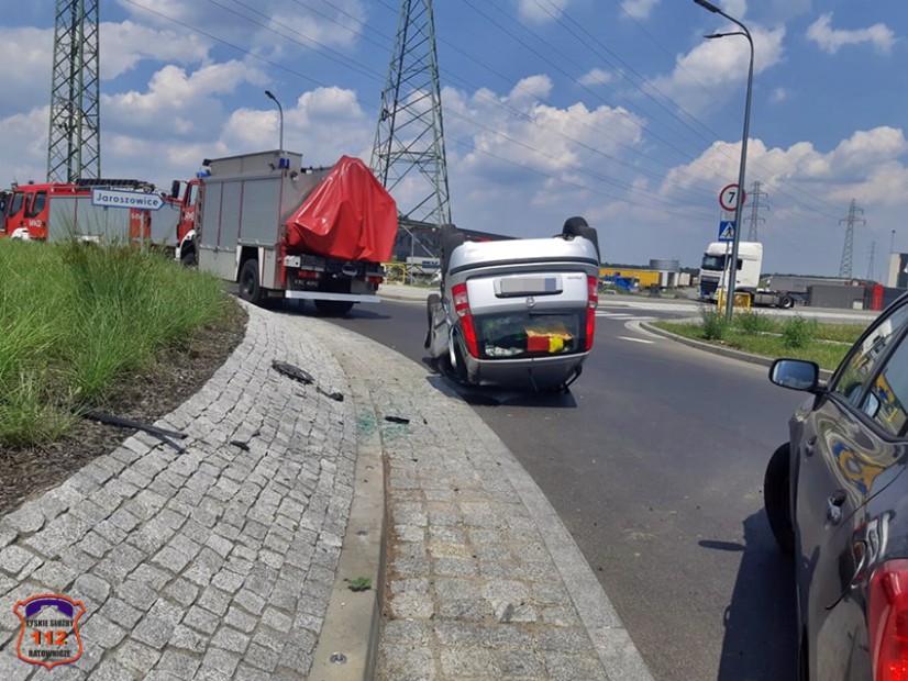 Na zdjęciu widoczny wydachowany samochód w rejonie ronda, dalej dwa wozy straży pożarnej. 