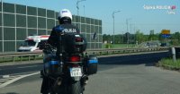 Obrazek przedstawia policjanta jadącego na policyjnym motocyklu