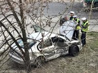 Obrazek przedstawia rozbity pojazd a wokół niego trzech umundurowanych policjantów wykonujących czynności na miejscu zdarzenia