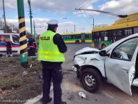 Obrazek przedstawia umundurowanego policjanta obok rozbity samochód z wypadku  , w tle karetka po lewej stronie a po prawej dwa autobusy