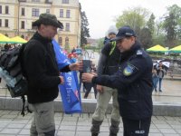 Obrazek przedstawia stojących na scenie dwóch nieumundurowanych policjantów, jeden z nich trzyma flagę &quot;Wyprawa dla Jasia&quot; drugi na plecach w foteliku trzyma chłopca-Jasia. Komendant miejski Policji w Tychach insp. Andrzej Trzciński wręcza im podziękowania.