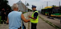 Na zdjęciu widoczna symulacja wypadku drogowego-potrącenie rowerzysty przez autobus oraz rozmawiającego z rowerzystą policjanta ruchu drogowego, po lewej stronie widoczni strażacy