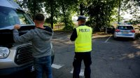 Kierowca zamyka klapę, policjant idzie w stronę radiowozu.