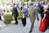 Komendant Miejski Policji insp. Andrzej Trzciński, trzymający kwiaty, w obecności innych mundurowych oraz osób postronnych, podczas uroczystości obchodów 100. rocznicy wybuchu I powstania śląskiego.