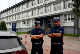 Na zdjęciu widocznych dwóch umundurowanych policjantów z ruchu drogowego, którzy stoją przed budynkiem Komendy Miejskiej Policji w Tychach.