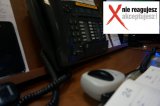 Na zdjęciu widoczny telefon oraz radiostację, a w prawym górnym rogu napis: &quot;Nie reagujesz-akceptujesz&quot;