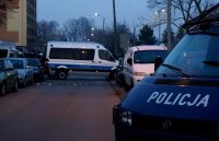 Na zdjęciu widoczny napis &quot;POLICJA&quot; z maski radiowozu, dalej drugi radiowóz stojący w poprzek drogi. Widoczne także cywilne samochody.