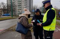 Policjanci wręczają pieszej odblask.