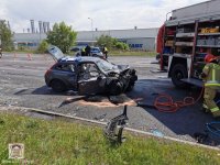 samochód marki VOLVO po wypadku przed samochodem stoi wóz Straży Pożarnej w tle widać oznakowany policyjny radiowóz oraz dwóch umundurowanych policjantów wykonujących czynności