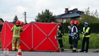 pomarańczowy parawan za którym wykonywane są czynności w związku z zaistniałym wypadkiem na zdjęciu widoczni są policjanci i strażacy