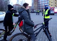 Policjant ruchu drogowego rozmawia z młodymi rowerzystami.