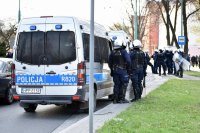 Policyjny radiowóz i policjanci zabezpieczający rejon stadionu miejskiego.