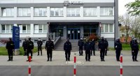 Policjanci wraz z funkcjonariuszami Straży Pożarnej oraz Straży Miejskiej stoją przed budynkiem Komendy Miejskiej Policji w Tychach.