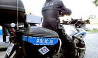 Policyjny motocykl, na którym siedzi policjant.