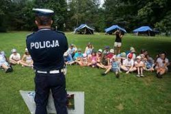 Policjant stoi przodem do grupy dzieci.