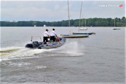 Policjanci płyną motorówką.