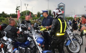 Uczestnicy pikniku, motocykliści, policjant ruchu drogowego.