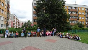 Policjanci z grupą dzieci i ich opiekunami.