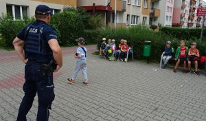 Policjant, a przed nim grupka dzieci.