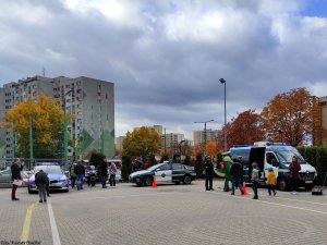 Radiowozy policji, inspekcji transportu drogowego pomiędzy nimi osoby.