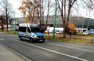 Policyjny radiowóz, w tle stadion miejski.