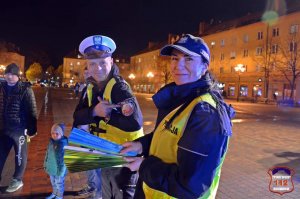 Policjantka trzyma odblaski obok policjant.