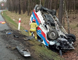 Pojazd karetki pogotowia po wypadku drogowym, w rowie na dachu.