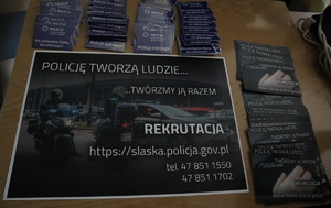 Ulotki &quot;Policję tworzą ludzie-twórzmy ją razem&quot; oraz gadżety na stoisku promocyjnym policjantów.