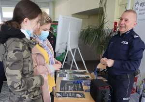 Umundurowany policjant rozmawia z kobietami.