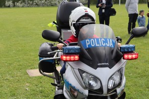 Chłopczyk z założonym kaskiem siedzi na policyjnym motocyklu.