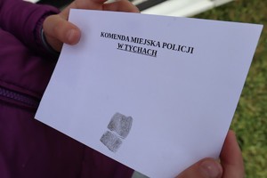 Kartka z napisem: Komenda Miejska Policji w Tychach oraz odcisk palca.