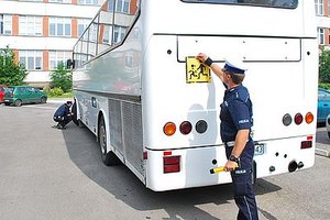 Policjant kontroluje autokar.