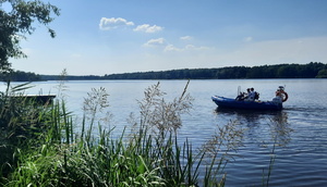 Na jeziorze Paprocańskim pływają policjanci na policyjnej łódce.