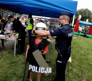 Policjant z dzieckiem zakładającym sprzęt policyjny