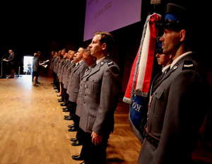 Policjanci nominowani na wyższe stopnie policyjne stojący na scenie podczas uroczystości.