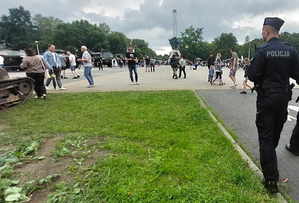 Widoczny umundurowany policjant i uczestnicy obchodów Święta Wojska Polskiego.