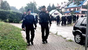 Widocznych dwóch policjantów dowodzących akcja zabezpieczenia meczu dalej policjanci w hełmach i kamizelkach.