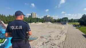 Umundurowany policjant patrzy w kierunku skateparku.