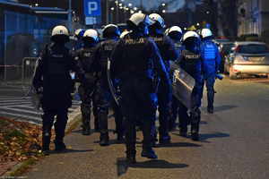 Policjanci w hełmach oraz z tarczami podczas zabezpieczenia meczu GKS Tychy z Ruch Chorzów .