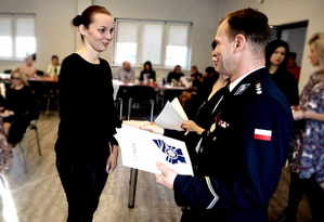 Kobieta przyjmuje od Zastępcy Komendanta Miejskiego Policji w Tychach podziękowania z okazji Święta Służby Cywilnej.
