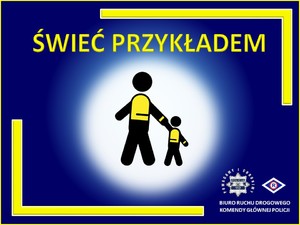 Plakat informacyjny z napisem świeć przykładem.. Na środku rysunek dwóch postaci trzymających się za rękę. Postacie ubrane w żółte kamizelki. W prawym dolnym rogu logo policji oraz logo ruchu drogowego.