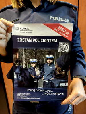 Umundurowana policjantka trzyma  w reku plakat