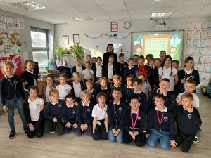 Na zdjęciu grupa dzieci i umundurowana policjantka