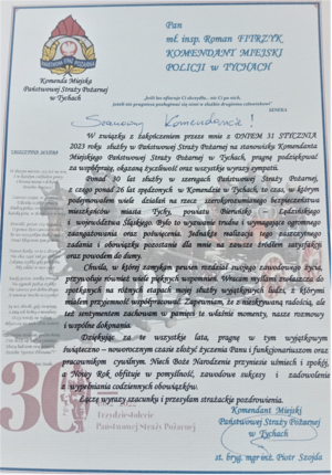 Zdjęcie podziękowań skierowanych do Komendanta Miejskiego Policji w Tychach- mł. inspektora Romana Fitrzyka o treści: Szanowny Komendancie! W związku z zakończeniem przeze mnie z dniem 31 stycznia 2023 roku służby w Państwowej Straży Pożarnej na stanowisku Komendanta Miejskiego Państwowej Straży pożarnej w Tychach, pragnę podziękować za współpracę, okazaną życzliwość oraz wszystkie wyrazy sympatii. Ponad 30 lat służby w szeregach Państwowej Straży Pożarnej, z czego ponad 26 lat spędzonych w Komendzie w Tychach, to czas, w którym podejmowałem wiele działań na rzecz szerokorozumianego bezpieczeństwa mieszkańców miasta Tychy, powiatu Bieruńsko-Lędzińskiego i województwa Śląskiego. Było to wyzwanie trudne i wymagające ogromnego zaangażowania oraz poświęcenia. Jednakże realizacja tego zaszczytnego zadania i obowiązku pozostanie dla mnie na zawsze źródłem satysfakcji oraz powodem do dumy. Chwila, w której zamykam pewien rozdział swojego zawodowego życia, przywołuje również wiele pięknych wspomnień. Wracam myślami zwłaszcza do spotkanych na różnych etapach mojej służby wyjątkowych ludzi, z którymi miałem przyjemność współpracować. Zapewniam, że z nieskrywaną radością, ale też sentymentem zachowam w pamięci te właśnie momenty, nasze rozmowy i wspólne dokonania. Dziękując za te wszystkie lata, pragnę w tym wyjątkowym świąteczno-noworocznym czasie złożyć życzenia Panu i funkcjonariuszom oraz pracownikom cywilnym. Niech Boże Narodzenie przyniesie uśmiech i spokój, a Nowy Rok obfituje w pomyślność, zawodowe sukcesy i zadowolenie z wypełniania codziennych obowiązków. Łączę wyrazy szacunku i przesyłam strażackie pozdrowienia. Komendant Miejski Państwowej Straży Pożarnej w Tychach st.bryg.mgr inż. Piotr Szojda.