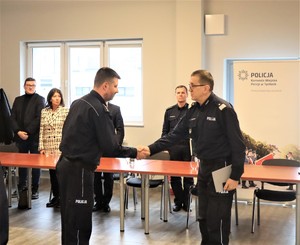 Na zdjęciu dwóch umundurowanych policjantów podających sobie dłonie.