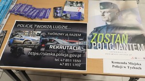 Na zdjęciu stolik, na którym rozłożone są ulotki zachęcające do pracy w Policji.